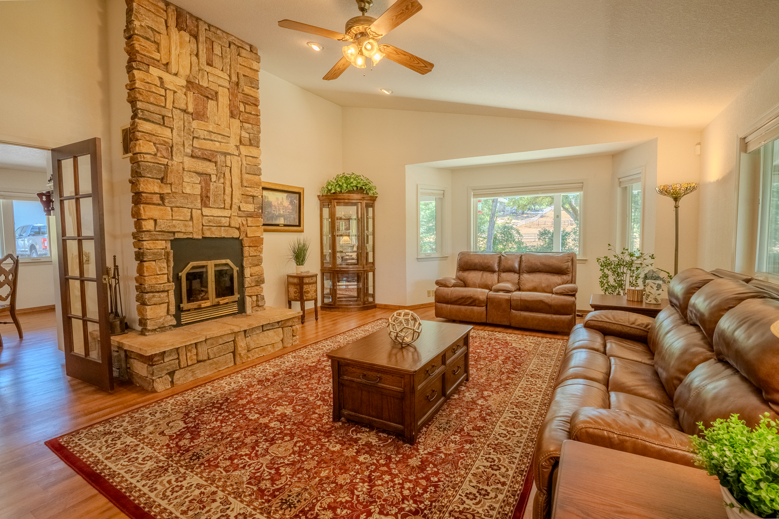 Living room with stone fireplace and hardwood floors