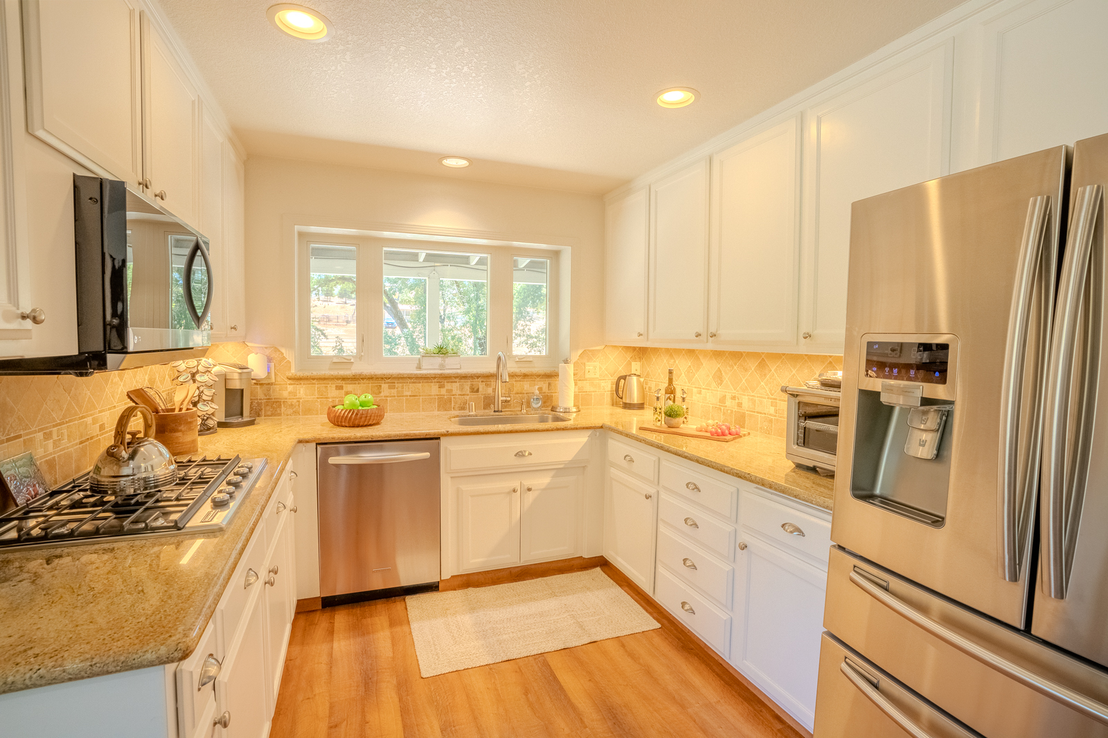 Bright kitchen with white cabinetry and granite countertops